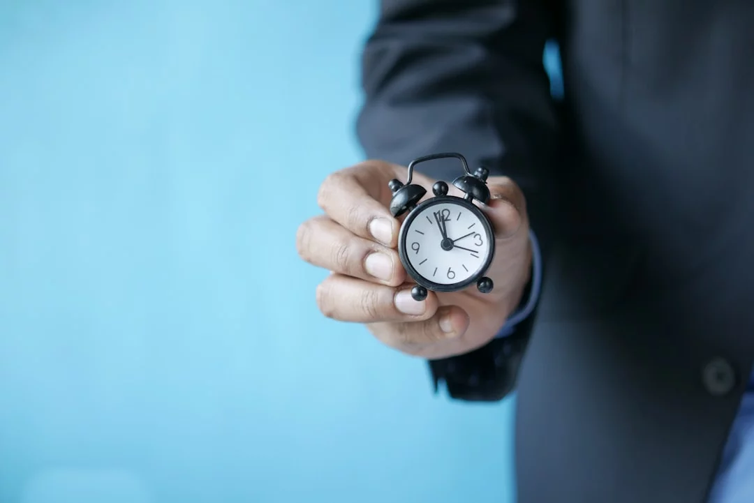 Man in a suit holding a small alarm clock, illustrating a deep work checklist and timing mistakes