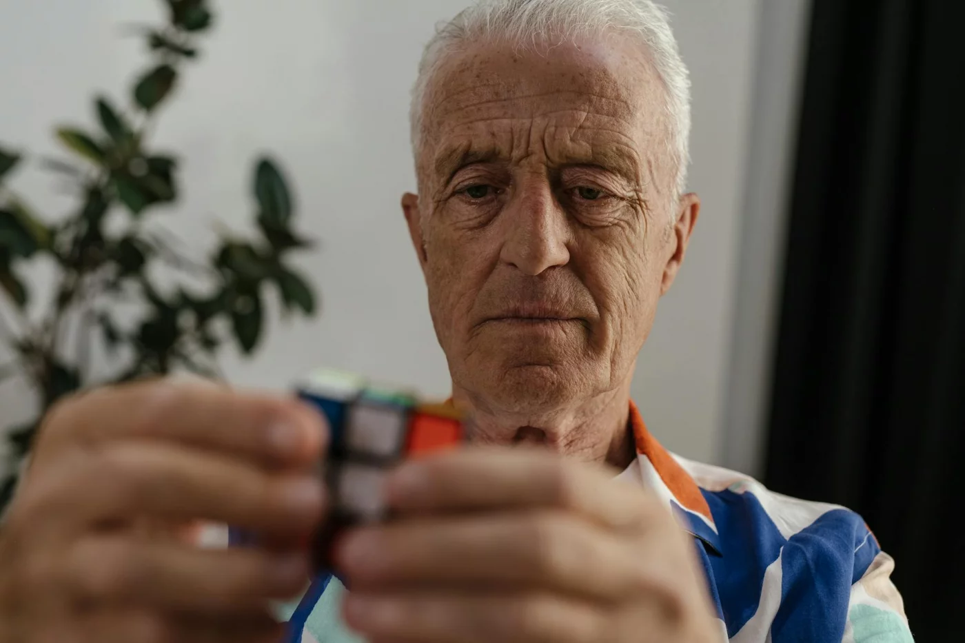 Does Education Protect Against Dementia? What Cognitive Reserve Really Means Elderly man solving a Rubik's Cube, reflecting on whether education protect against dementia through mental agility — does ed