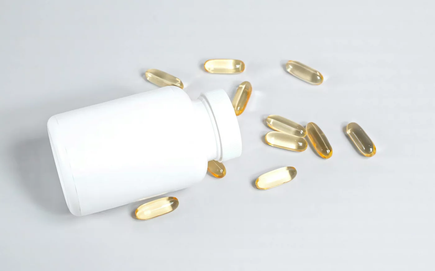 Omega-3 and Brain Function: 7 Checks Before You Buy Fish Oil Fish oil capsules spilled from a white bottle, illustrating does fish oil help cognitive function for some adults