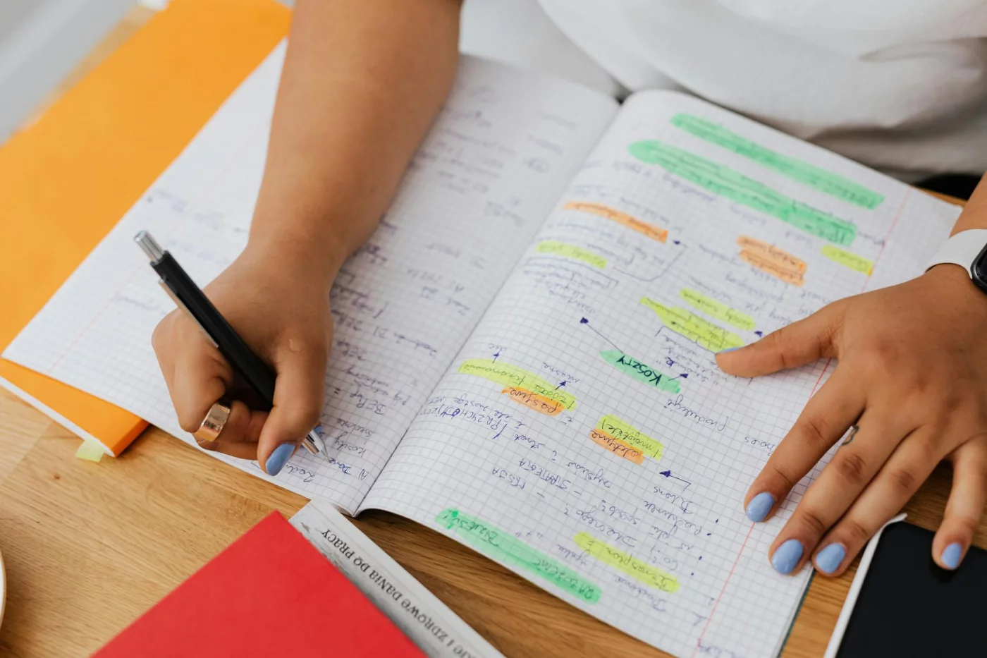 Dopamine, Motivation, Focus, and Learning: 7 Practical Habits Person writing and highlighting notes in a graph notebook to explore dopamine and learning and memory