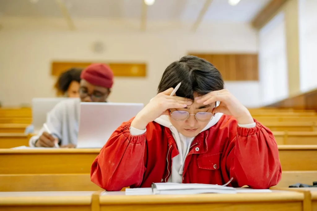 How Test Anxiety Affects Students and Which Study Skills Help Most University students studying intensely in a lecture hall, illustrating effects of test anxiety on students