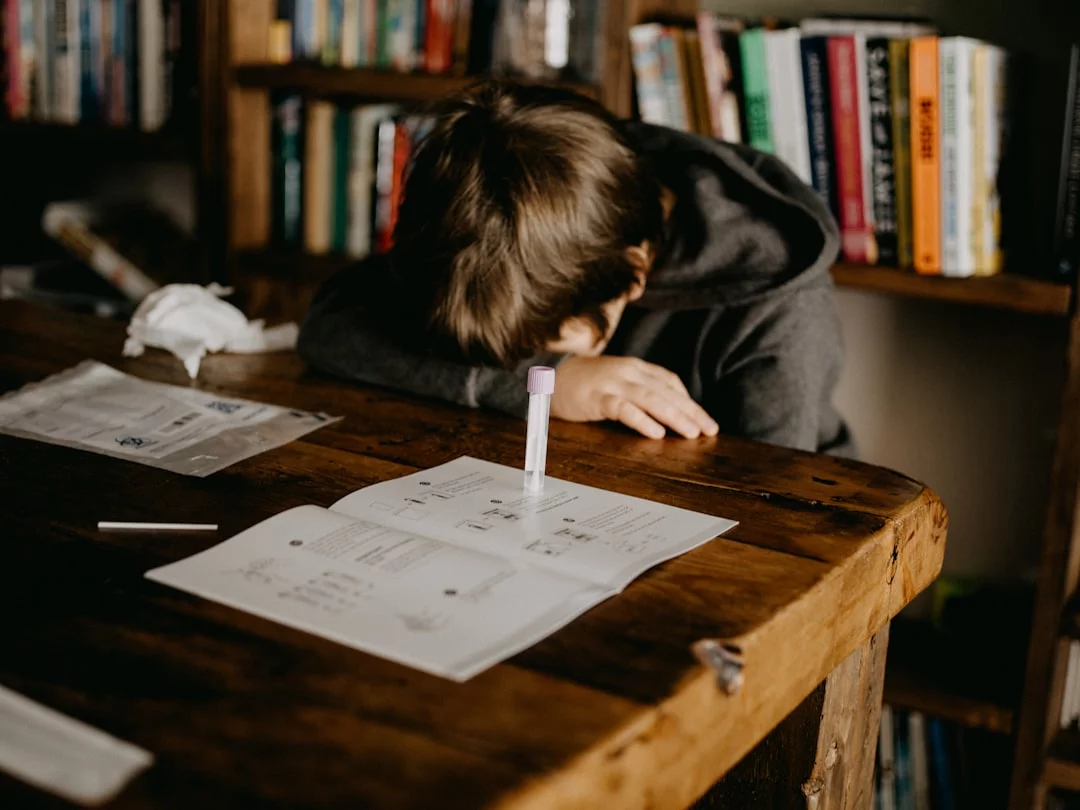 How Test Anxiety Affects Students and Which Study Skills Help Most Student in gray hoodie reading at a wooden table, reflecting the effects of test anxiety on students