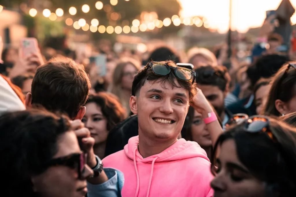 Face Blindness Test Meaning: How to Read Scores and What to Do Next Crowd surrounding a man in a pink hoodie, illustrating face blindness examples in everyday social settings
