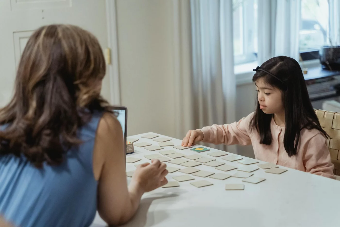 Mother and daughter play a card game, showing how do you increase neuroplasticity in the brain through play