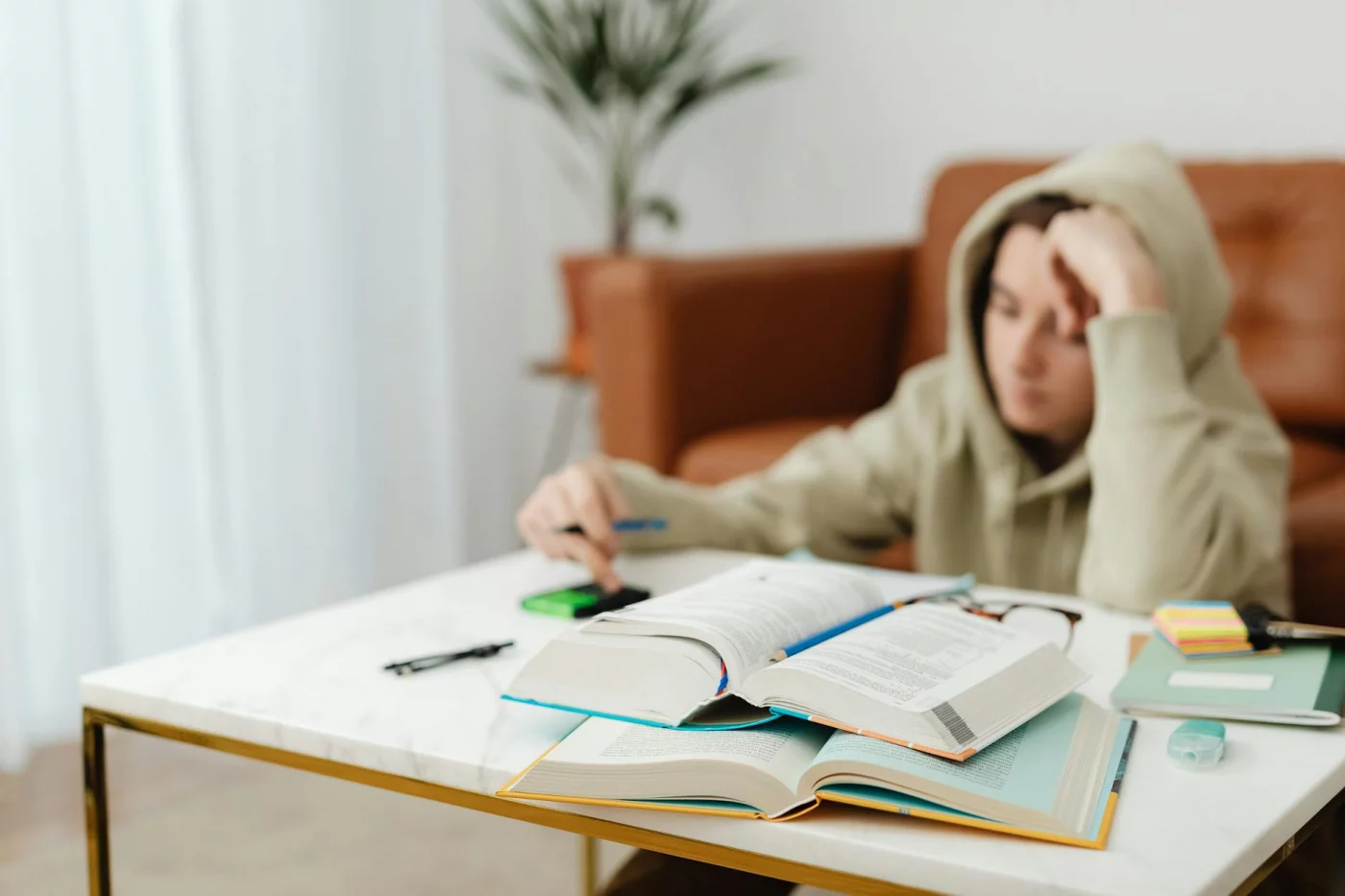 Teen studying with books and notes at a home desk, showing how does attention affect learning in real life