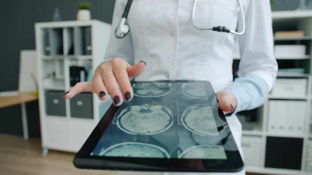 How the Hippocampus Shapes Learning, Memory, and Recall Doctor showing a brain scan on a tablet while explaining how does the hippocampus affect memory