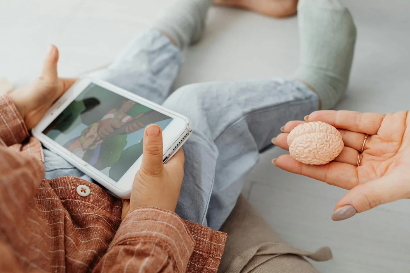 How the Hippocampus Shapes Learning, Memory, and Recall Adult holding a brain model beside a child on a tablet, showing how does the hippocampus affect memory