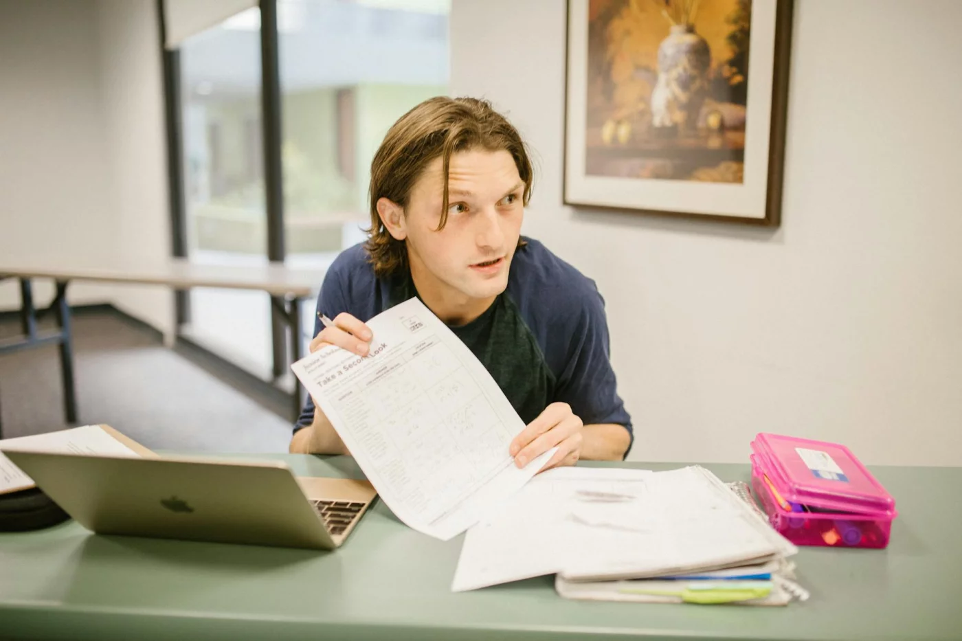 How Long Does Information Stay in Short-Term Memory? Student reviewing notes at a desk with a laptop, showing how long does short term memory last without rehearsal
