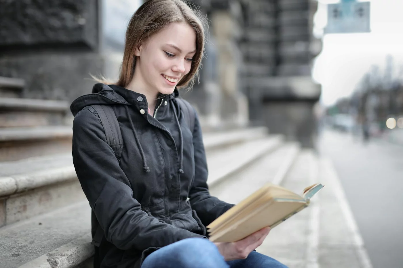 How Long Does Information Stay in Short-Term Memory? Woman reading on city steps, reflecting on how long does short term memory last without rehearsal