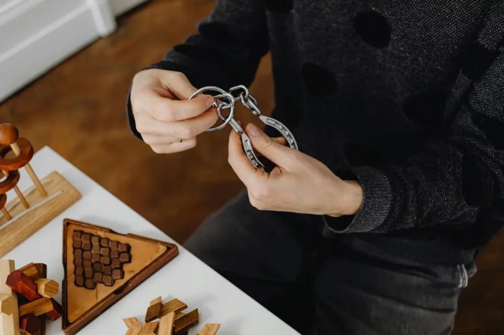 Hands solving a metal puzzle with brain teasers, illustrating how to improve memory and concentration naturally