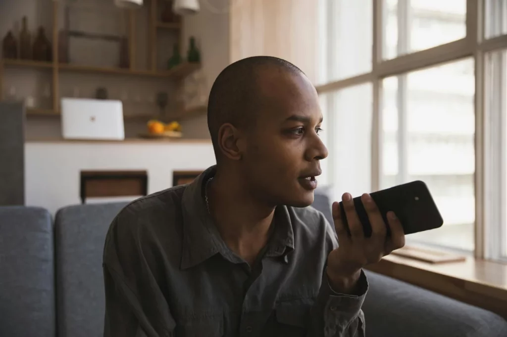 How to Practice Speaking a Language When You Don’t Have Native Friends Man using a smartphone on a sofa, demonstrating how to practice speaking a language by yourself at home