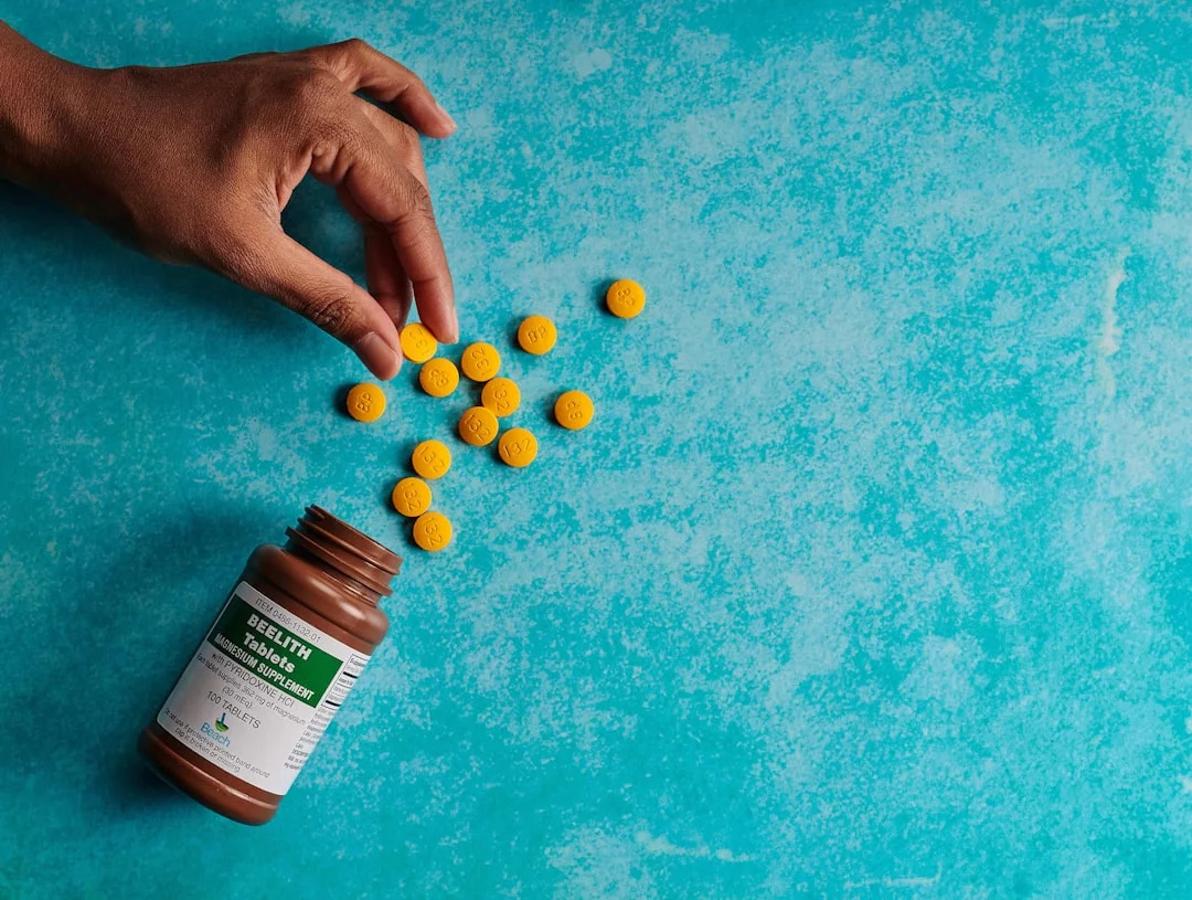 How to Prevent Alzheimer’s and Dementia: What Actually Helps Hand reaching for a bottle of pills on a blue surface in an FAQ about how to prevent alzheimer's and dementia