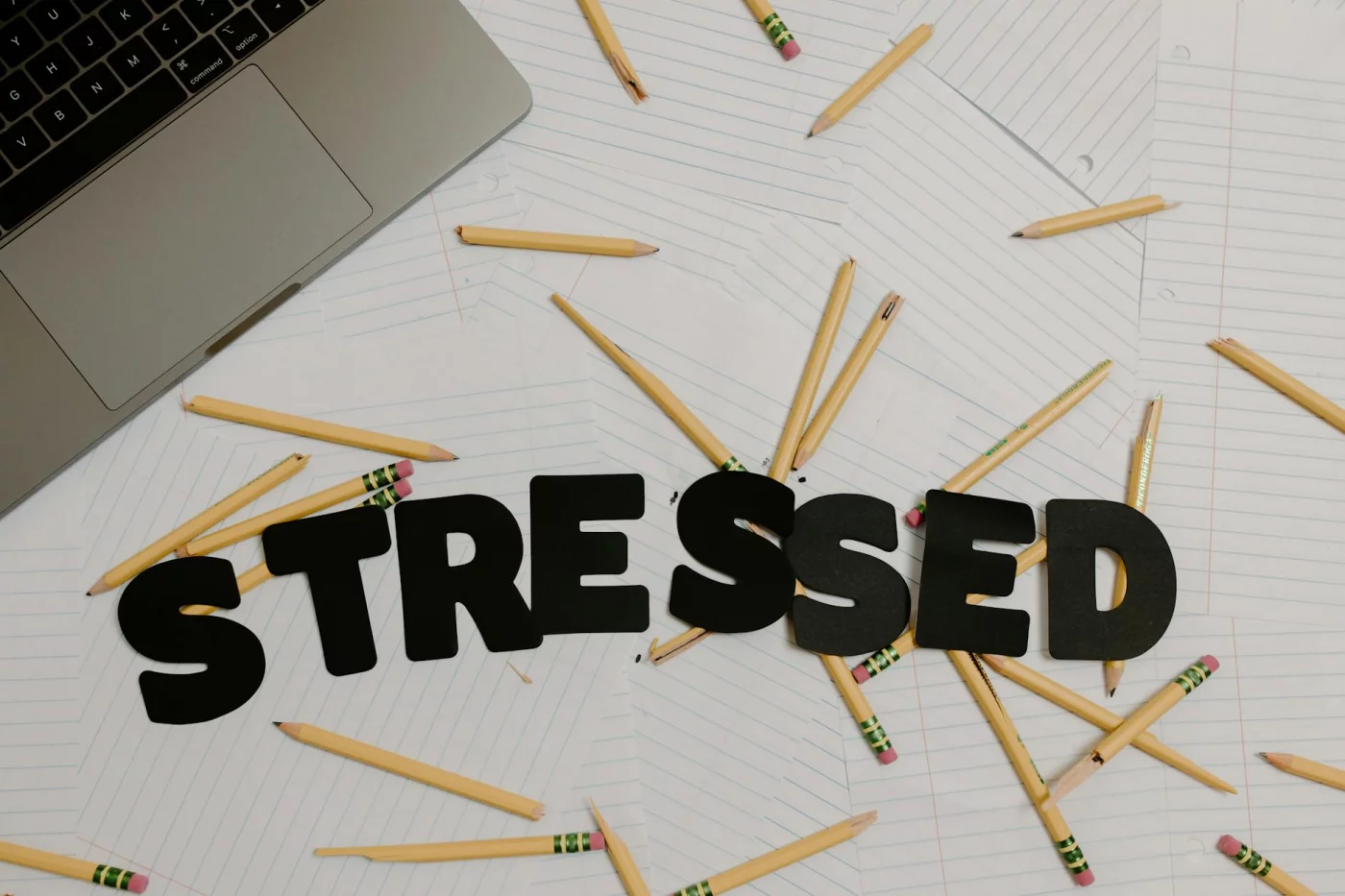 How to Reduce Stress Before a Test Without Wrecking Memory Recall Stressed desk setup with broken pencils and laptop showing how to reduce stress before a test in 7 steps