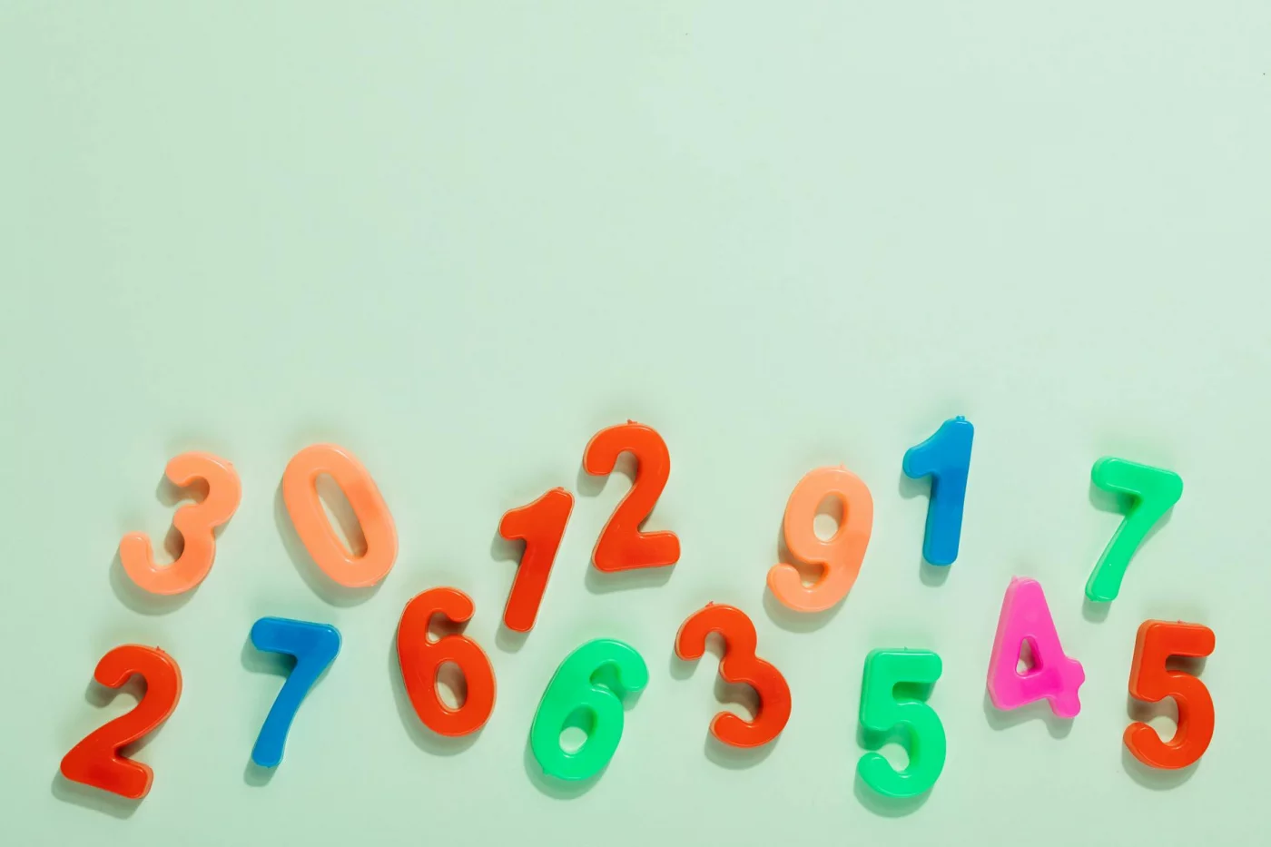 How to Remember Long Numbers With 5 Simple Memory Steps Bright plastic numbers on a mint green background illustrating how to remember long numbers with the Major System