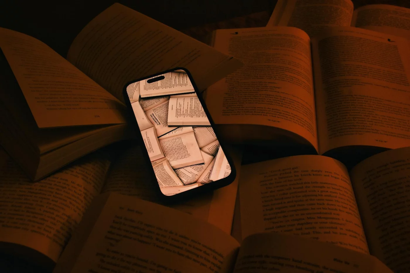 Smartphone on open books showing pages, illustrating how to skim a textbook chapter versus deep reading
