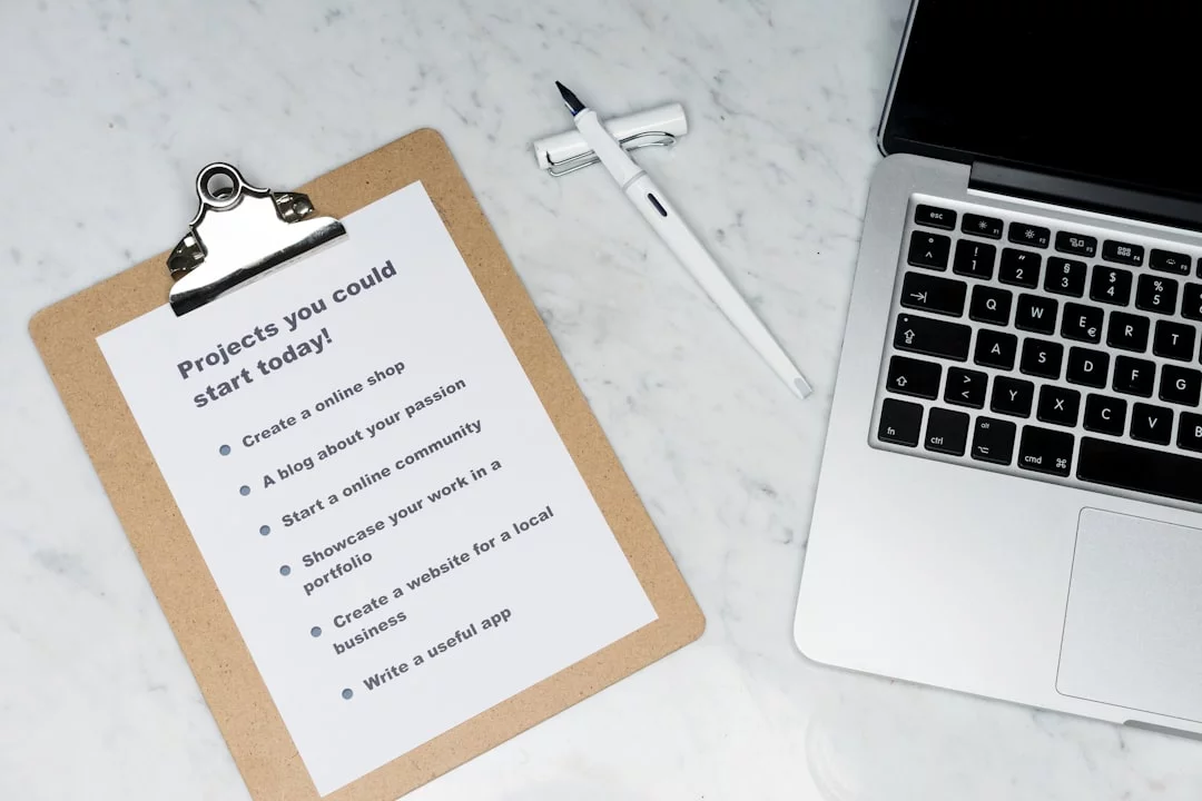 How to Stop Checking Email Every 5 Minutes With Email Batching FAQ notes beside a silver laptop on white paper about how to stop obsessively checking email