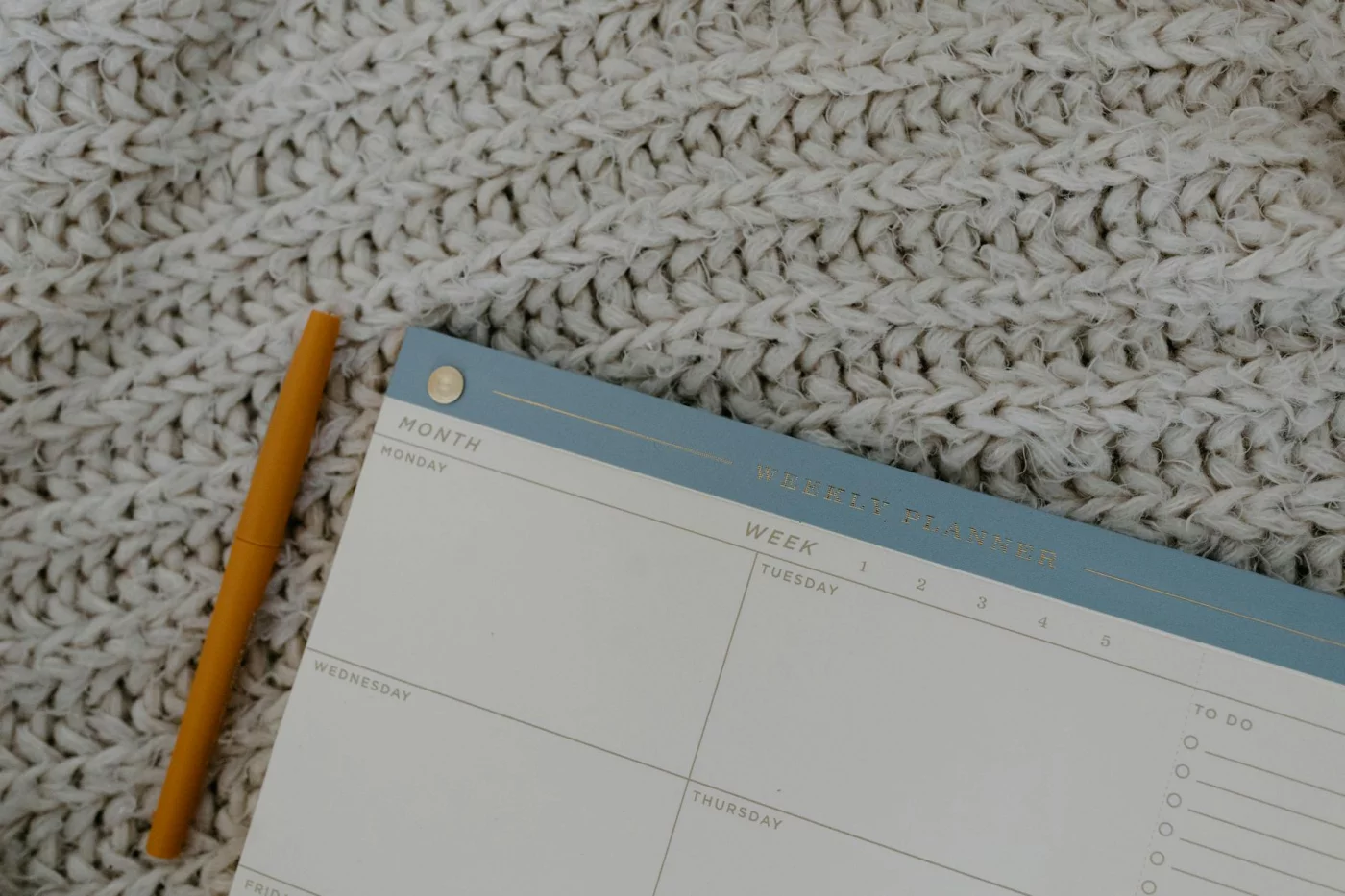 How to Study for the CPA Exam While Working: An 8-Step Plan Weekly planner and pen for organizing study time, showing how to study for cpa exam while working effectively