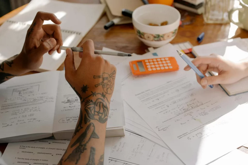 How to Study for Finals in a Week With a Realistic Plan Students reviewing notes and textbooks together, showing how to study for finals in a week effectively