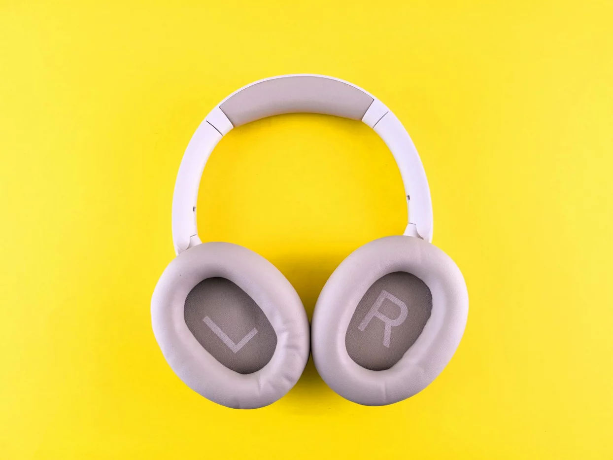 Wireless headphones on a yellow surface, a smart tool for how to study in a noisy house