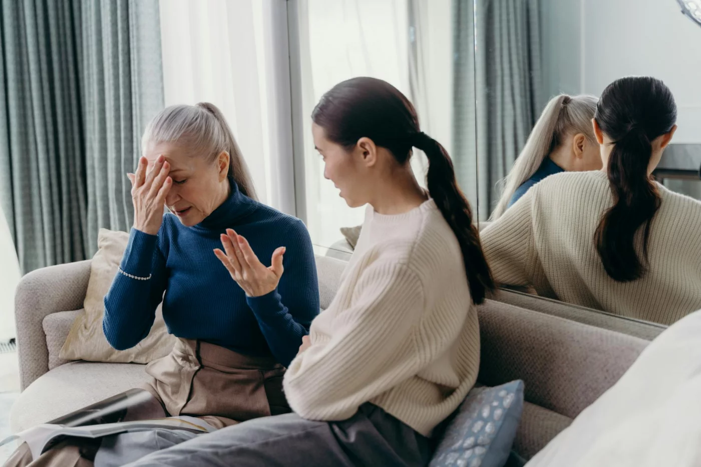 How to Talk to a Parent About Their Memory Loss Without Causing Panic Mother and daughter on a couch discussing how to talk to a parent about their memory loss calmly