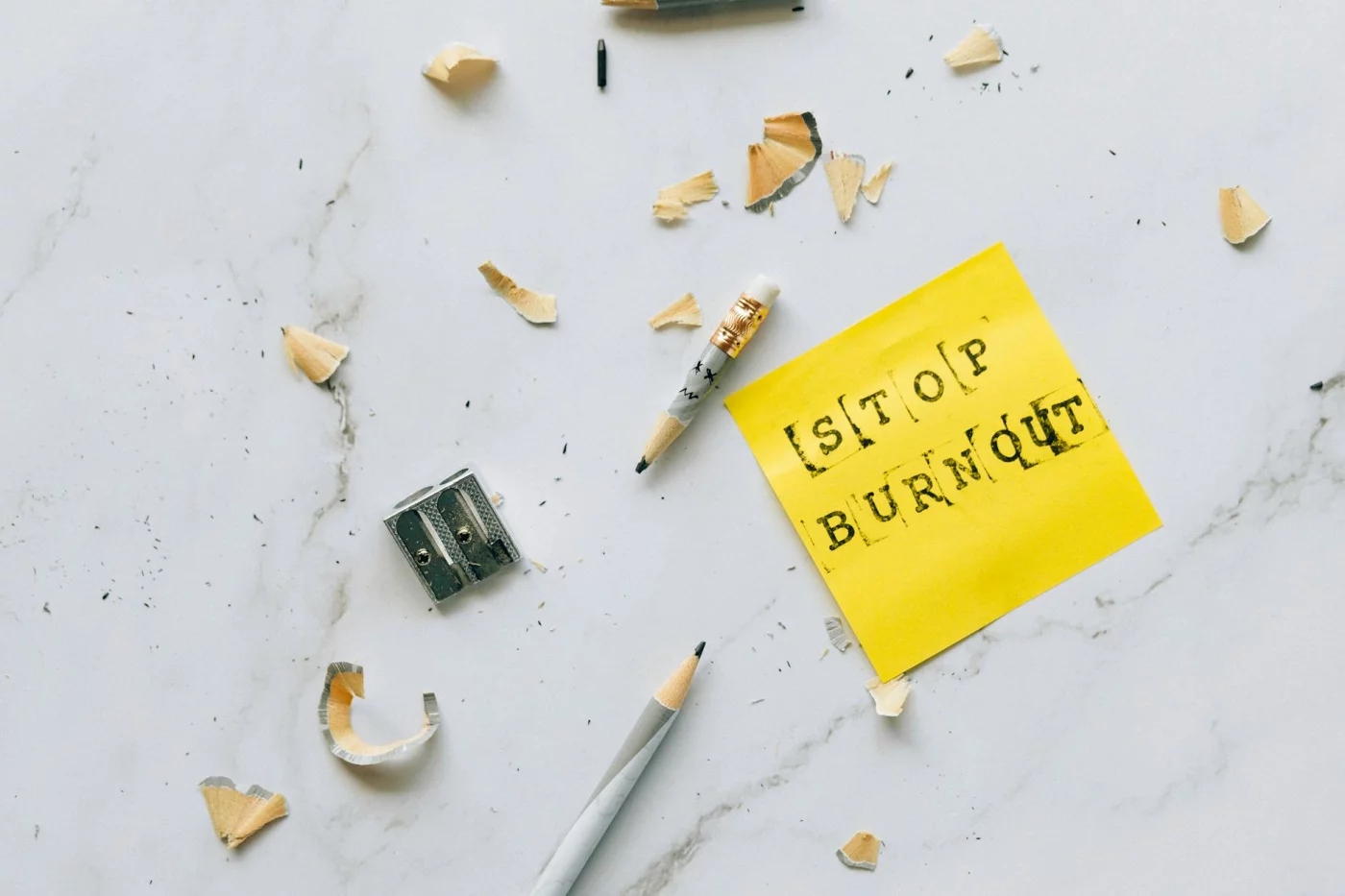 Toxic Productivity Explained: 7 Clear Ways to Escape Hustle Culture Stop Burnout note with pencil shavings on marble surface illustrating hustle culture meaning and stress relief