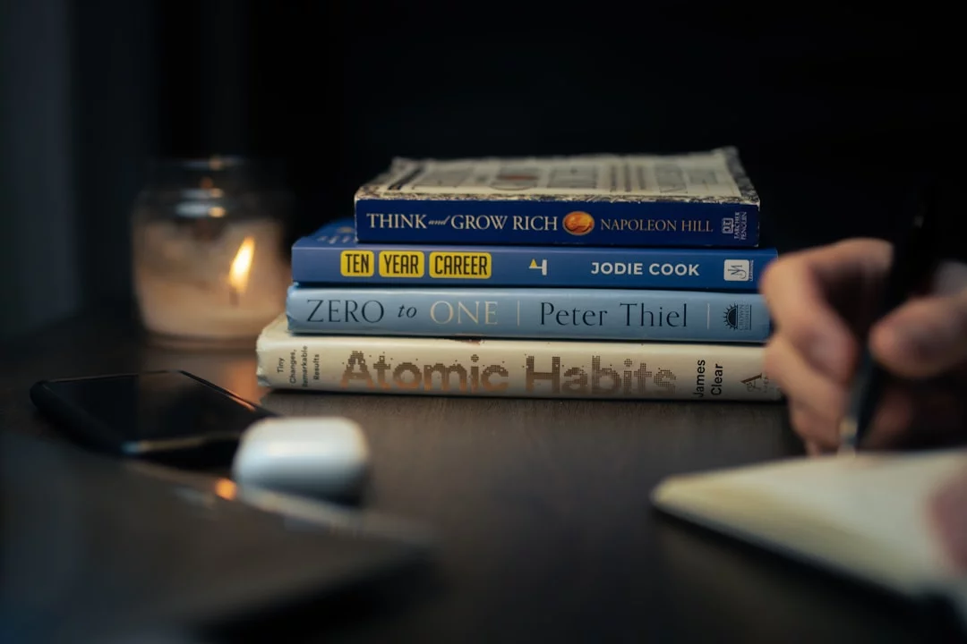 Stack of books on a wooden table illustrating identity based habits vs outcome based habits for students