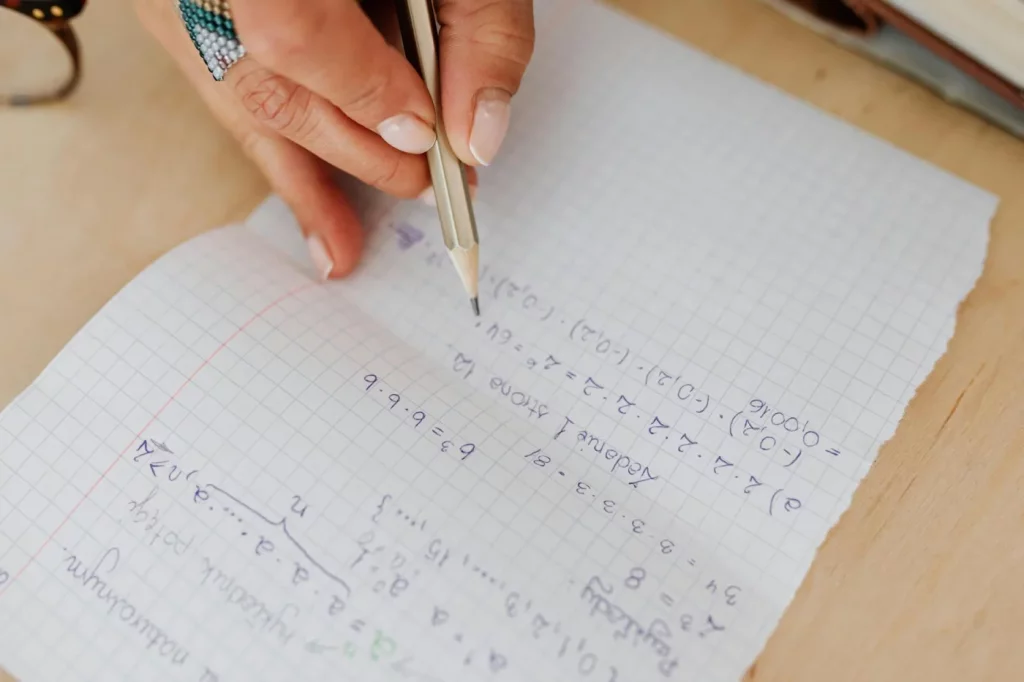 Interleaved Practice: How to Study Multiple Subjects in One Session Student solving math equations on grid paper with a pencil, illustrating interleaving practice in learning