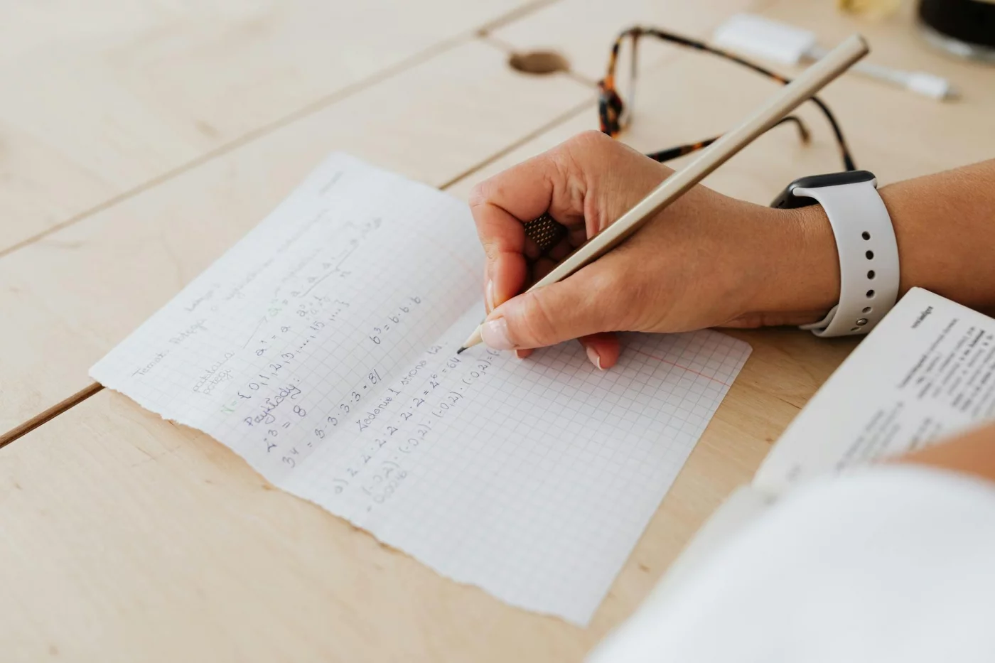 Interleaved Practice: How to Study Multiple Subjects in One Session Student solving mixed math problems on graph paper, showing interleaving practice over blocked drills