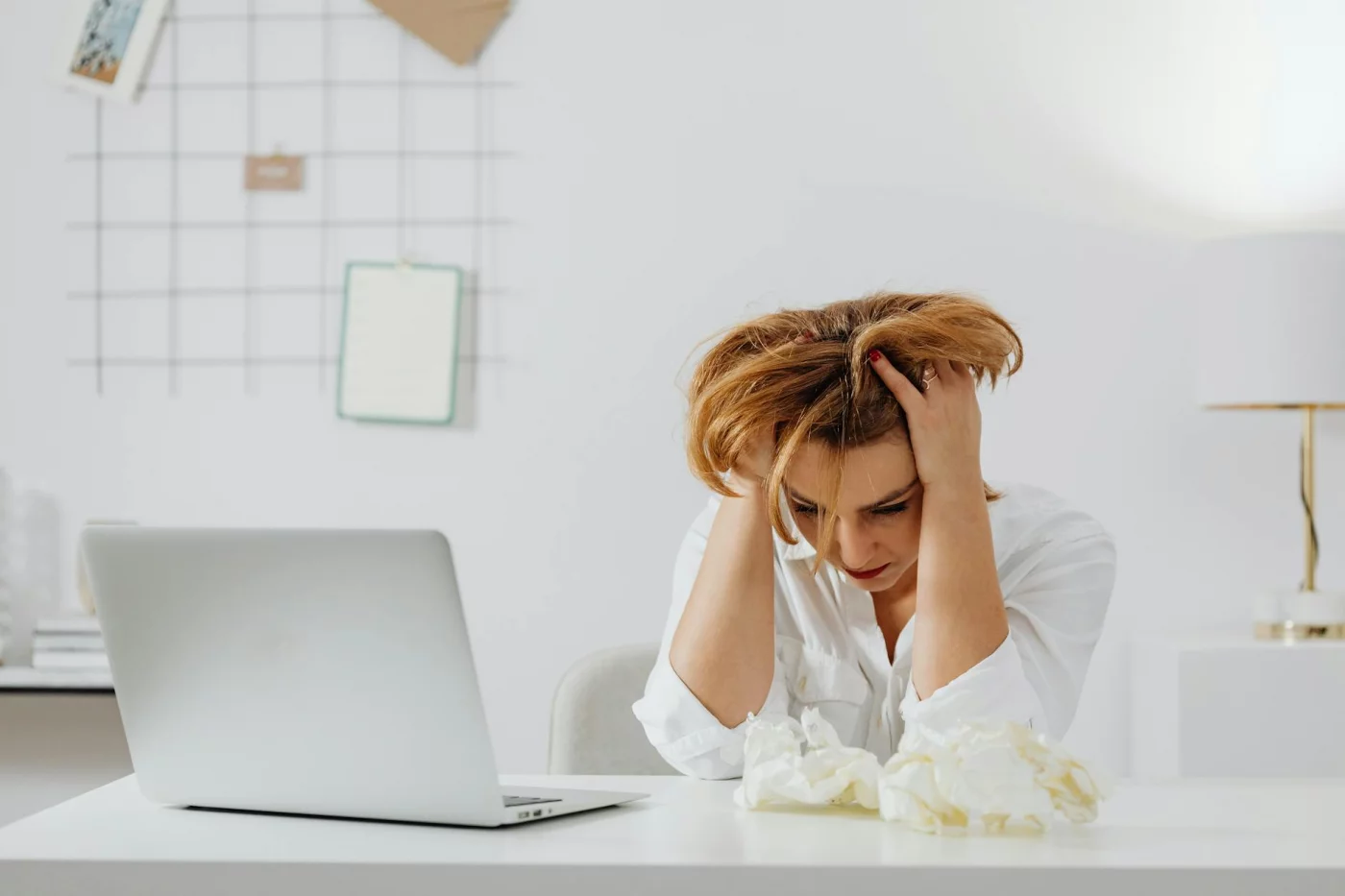 Is Memory Loss From Stress Reversible? What Stress Really Does to Memory Frustrated woman at her desk with a laptop, illustrating why people ask, is memory loss from stress reversible?