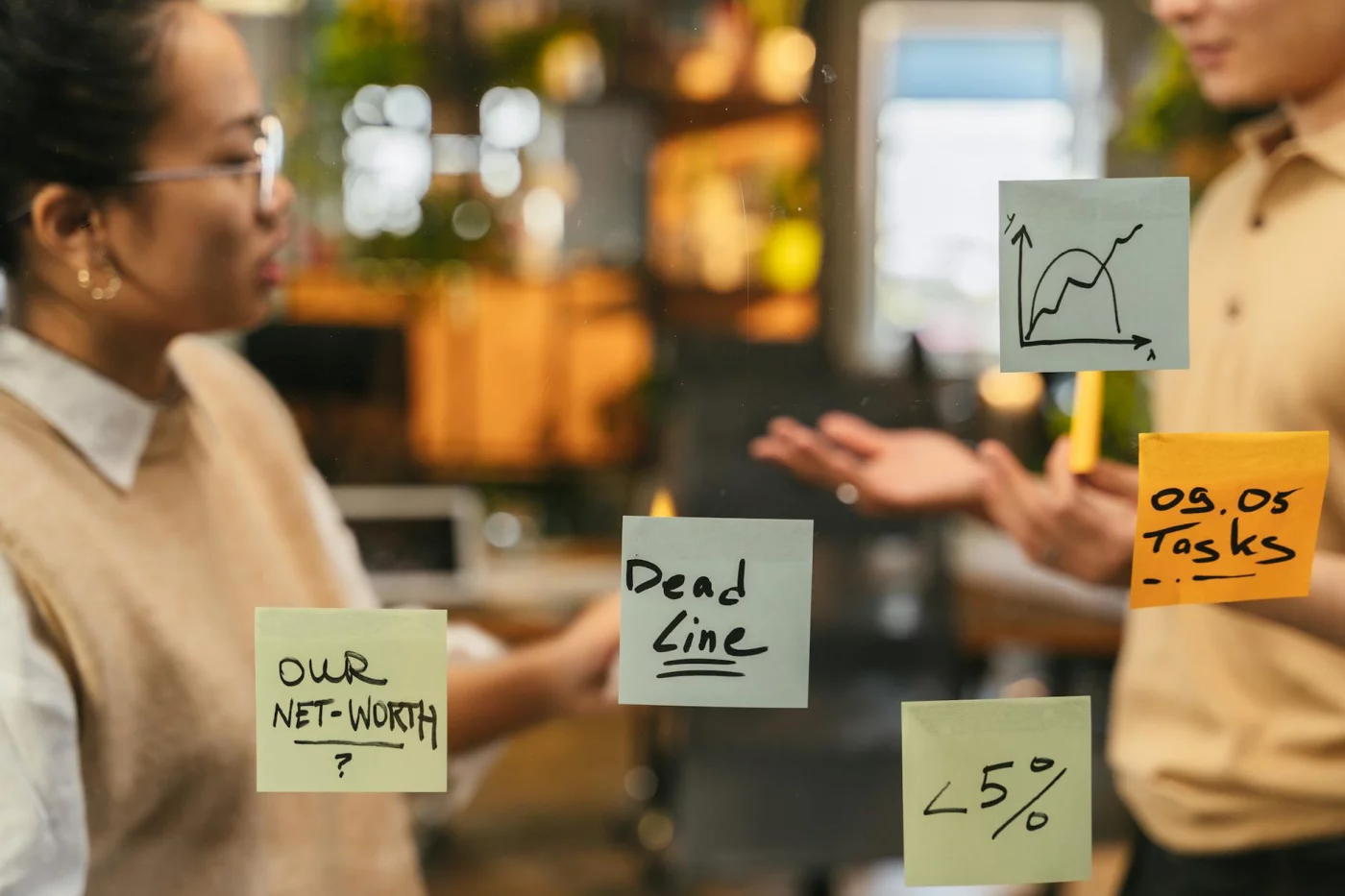 Shared vs Personal Note-Taking: When Sharing Notes Helps, Hurts, or Crosses a Line Students brainstorming with sticky notes on a glass wall while discussing whether is sharing notes academic misconduct