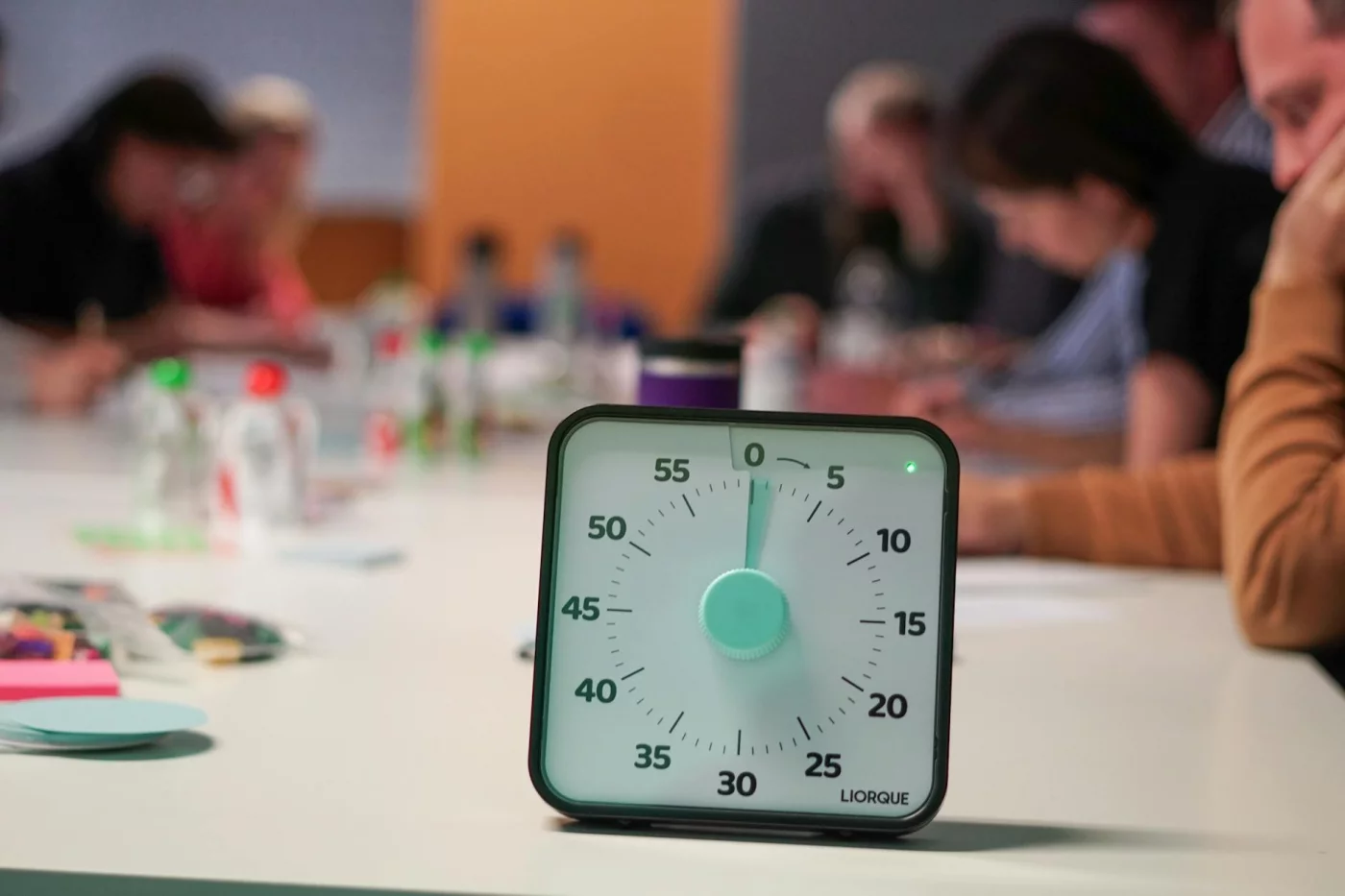 Timer on a table during an office meeting, illustrating why is time blocking good for adhd when sessions stay focused