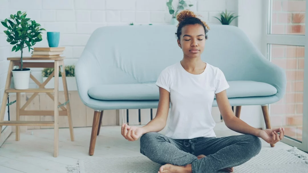Mindfulness for People Who Can’t Sit Still Young woman trying mindfulness exercises for anxiety while meditating on the floor at home
