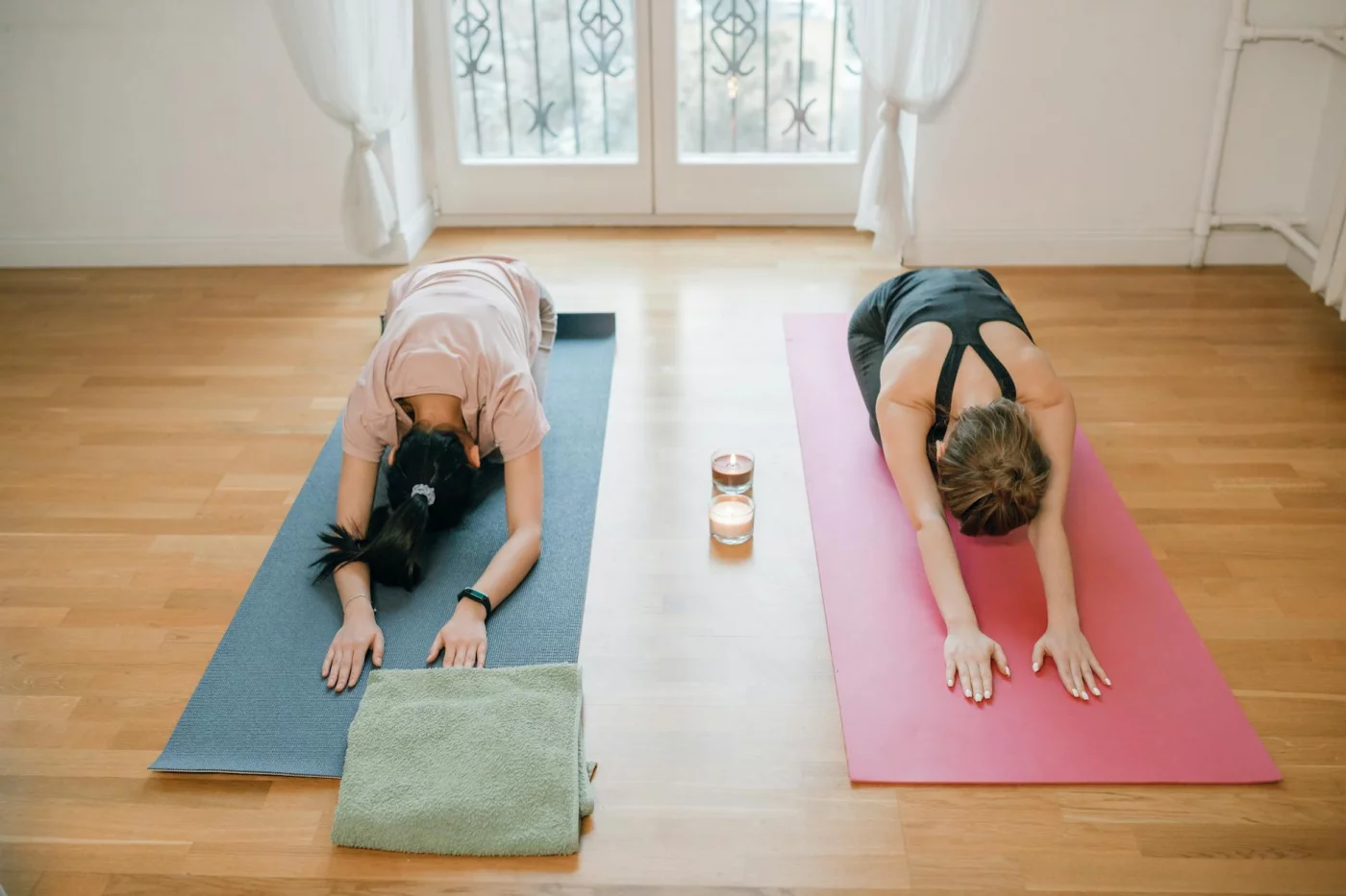 Mindfulness for People Who Can’t Sit Still Two women doing yoga on indoor mats as mindfulness exercises for anxiety and relaxation