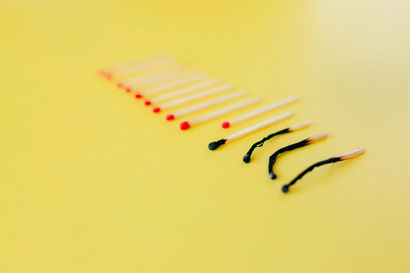 Workplace Burnout: 5 Stages and the Signs to Watch Burned-out match among intact matches on yellow background, symbolizing physical symptoms of burnout