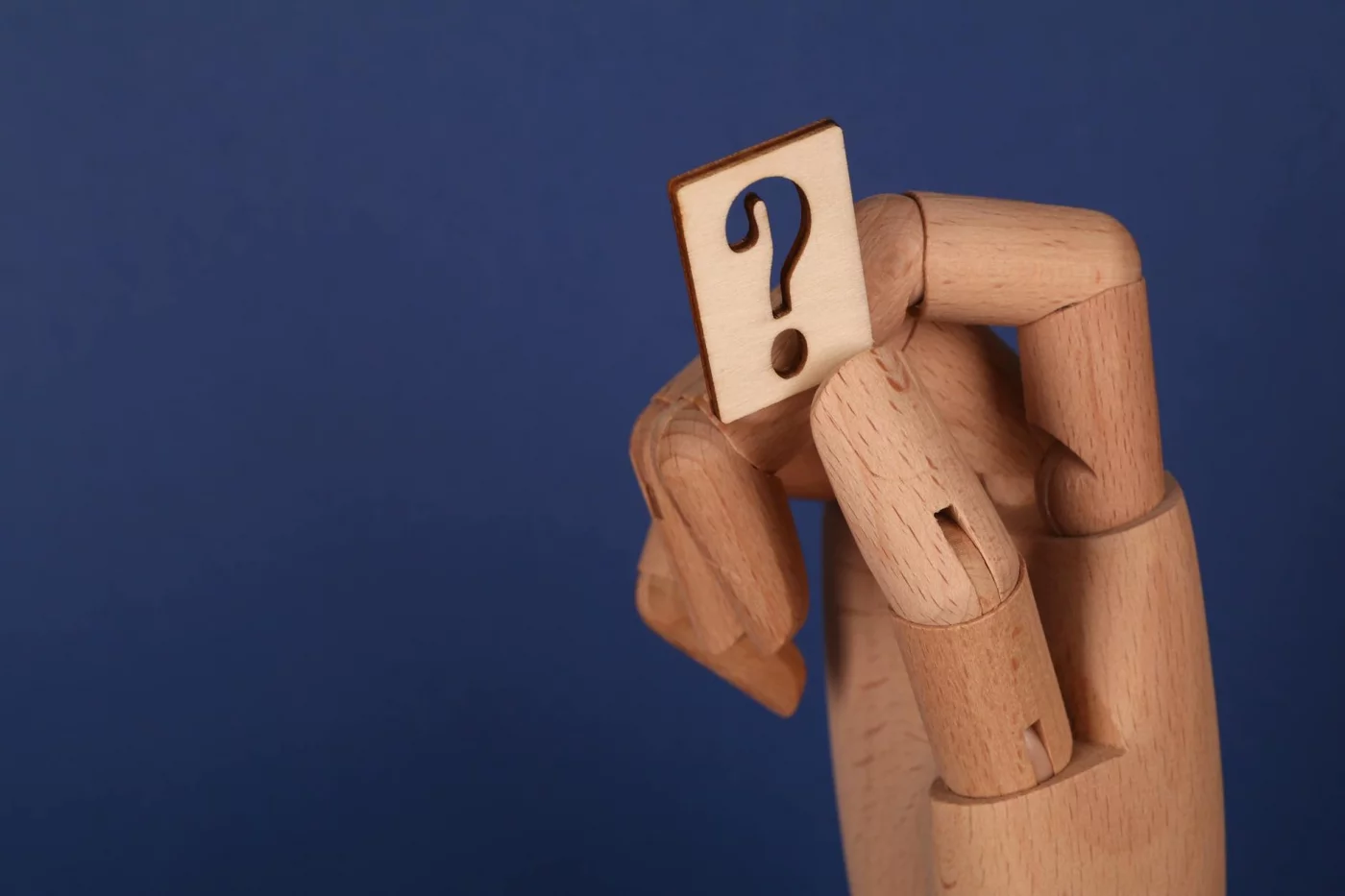 Human Benchmark Is Trending: What Online Memory Tests Really Measure FAQ concept for sage test online free with a wooden hand holding a question mark block on a blue background