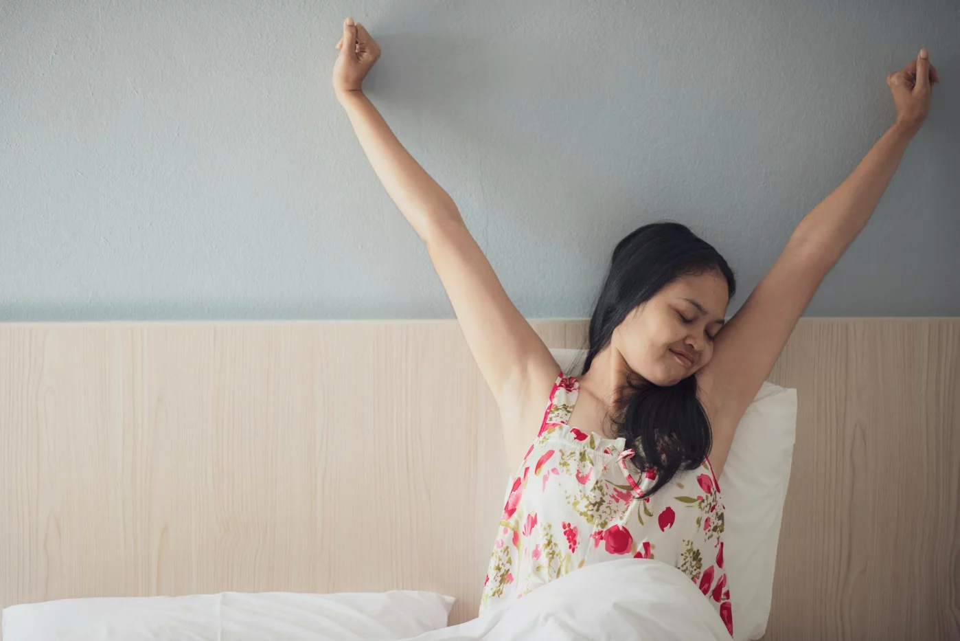 Brain-Friendly Morning Routines That Boost Focus Without 5 a.m. Wakeups Woman stretching in bed after waking, illustrating a scientifically proven best morning routine for focus and energy