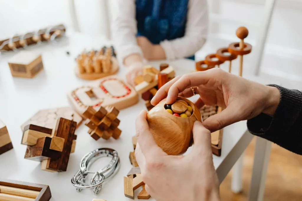 7 Signs Your Brain Is Rewiring and Why It Matters Hands solving wooden brain teasers indoors, illustrating signs your brain is rewiring through mental challenge