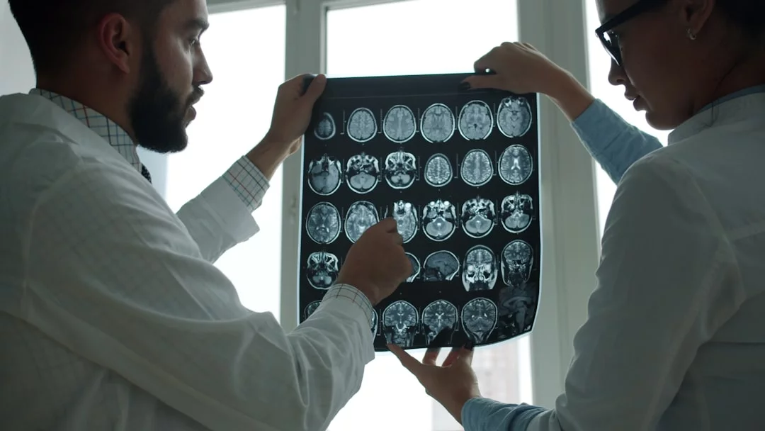 7 Signs Your Brain Is Rewiring and Why It Matters Two doctors reviewing a brain MRI scan, highlighting signs your brain is rewiring through modern research