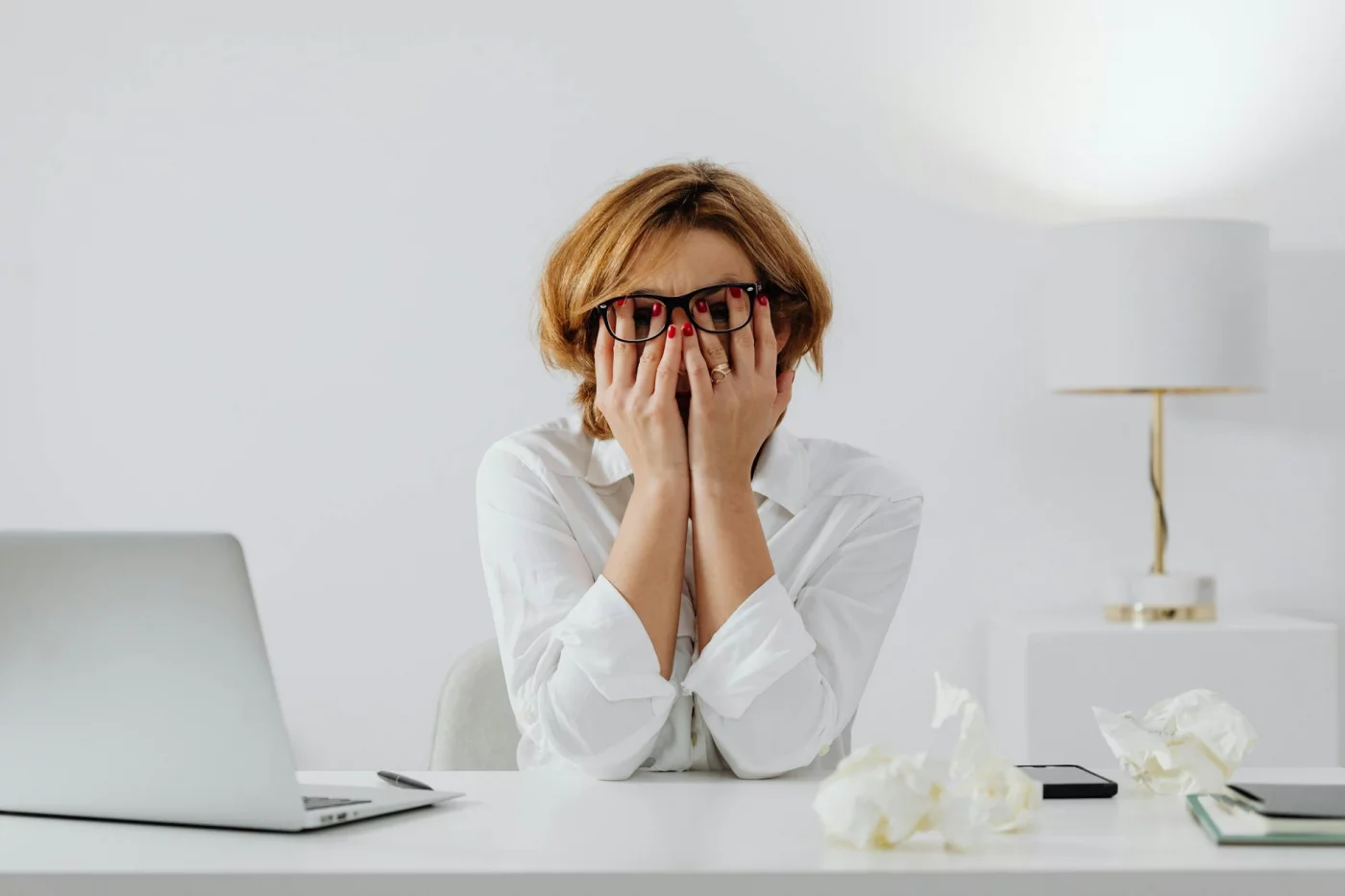 Stress, Focus, and Brain Health: 7 Practical Ways to Recover Woman at desk with laptop and tissues, showing how stress and memory problems can affect daily focus