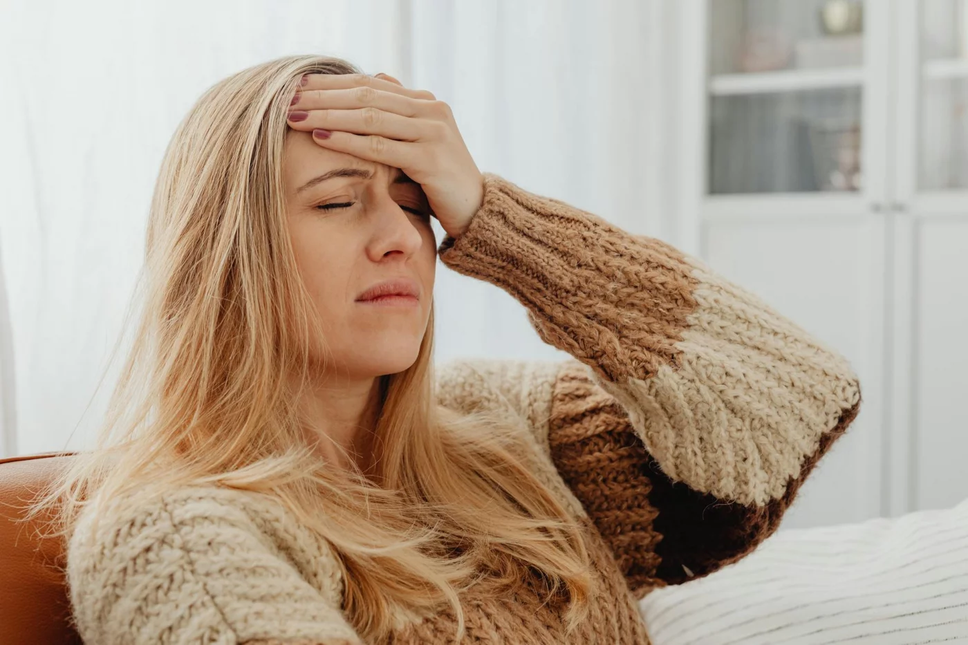Stress, Focus, and Brain Health: 7 Practical Ways to Recover Woman with a headache at home, illustrating stress and memory problems in daily life
