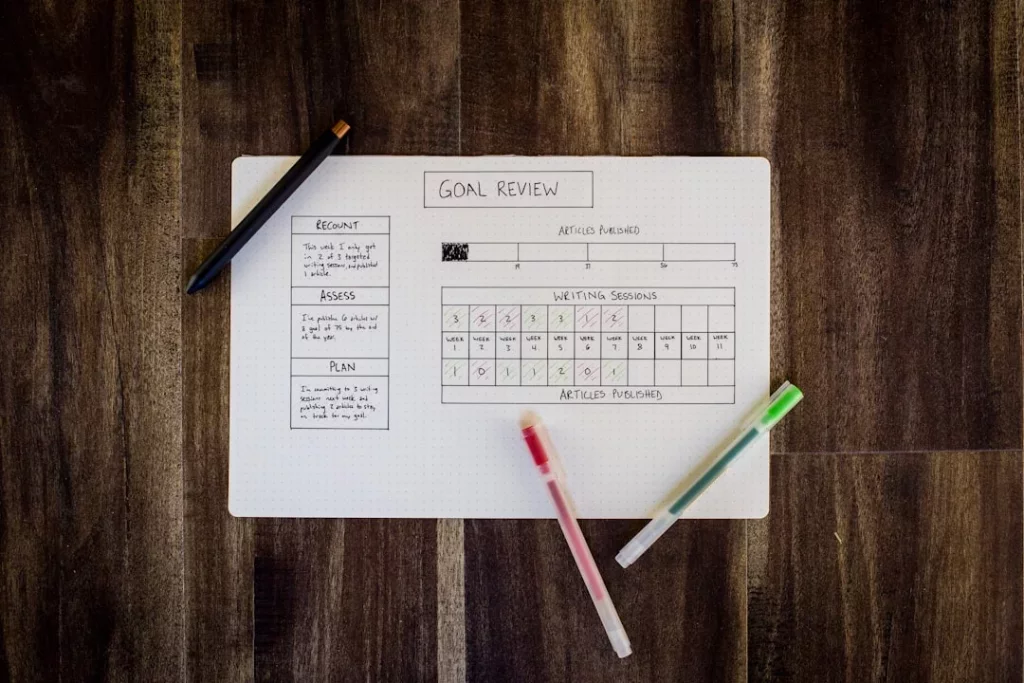 Three pens on white paper beside a study schedule template for planning a 30-day study routine
