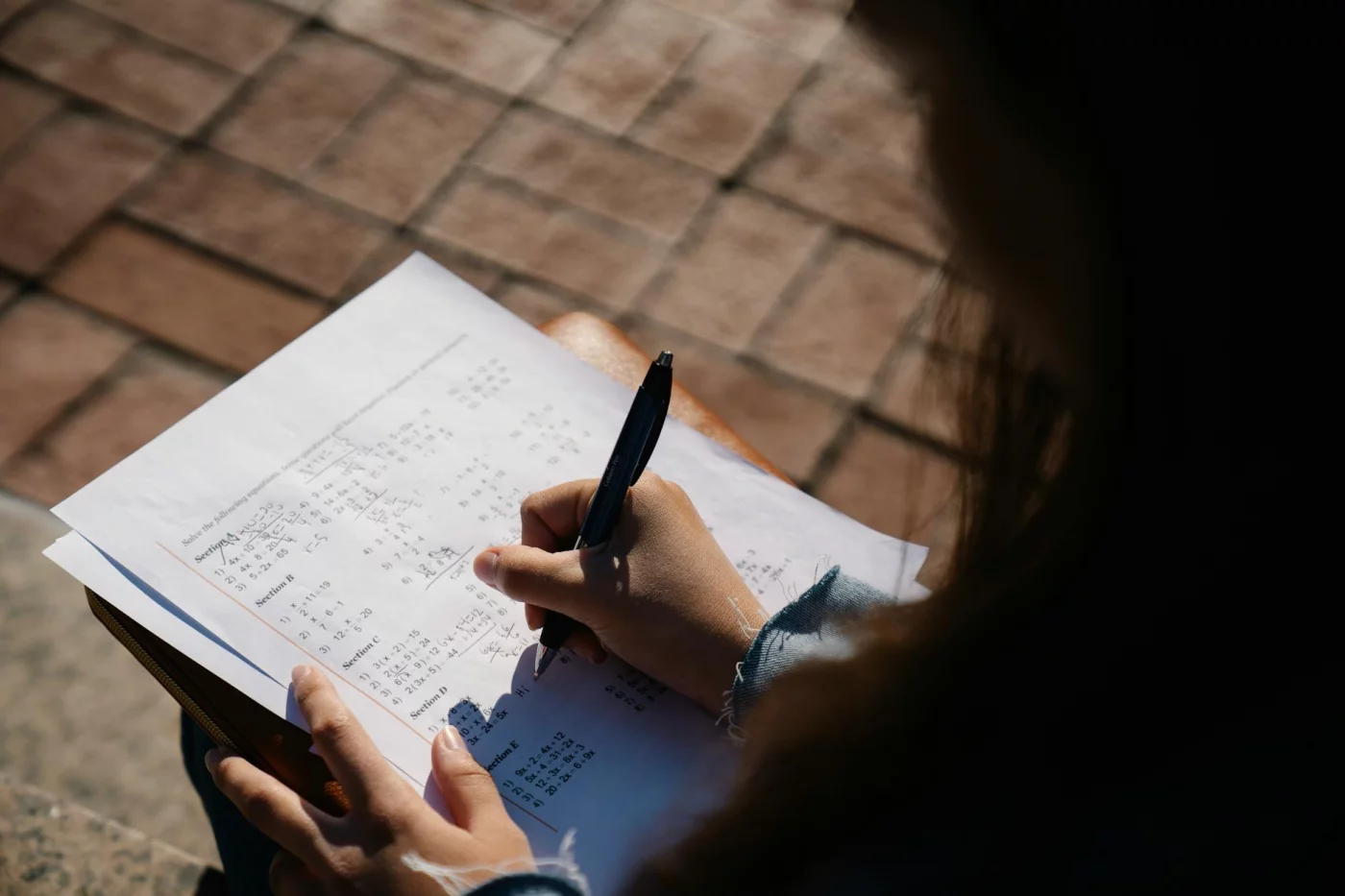 Student solving math problems outdoors while using CBT tips from a test anxiety strategies pdf before an exam