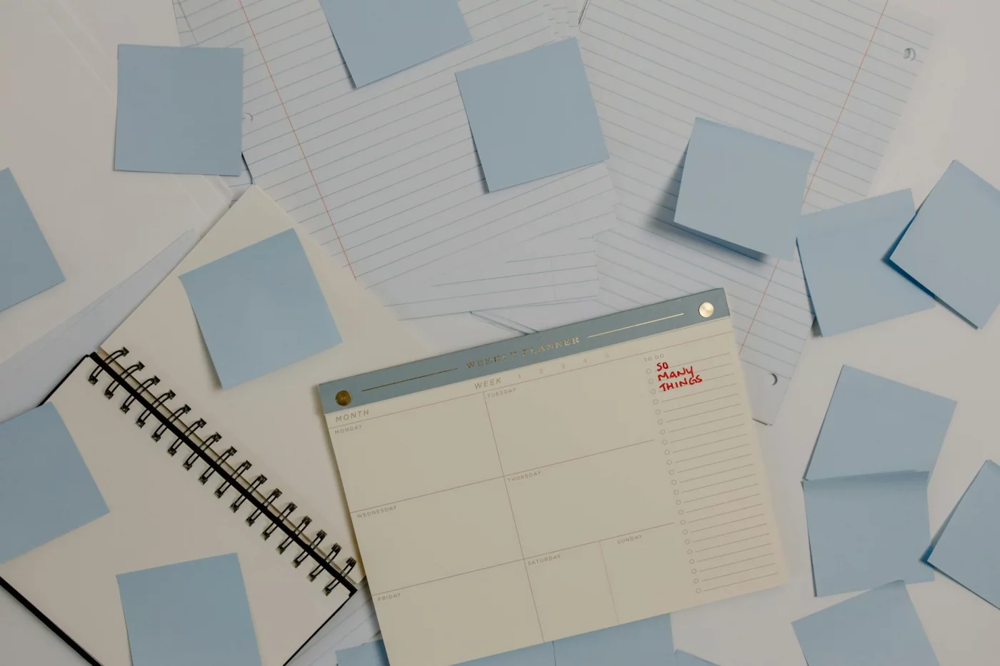Planner, sticky notes, and lined papers mapping a real week with time management tips for students