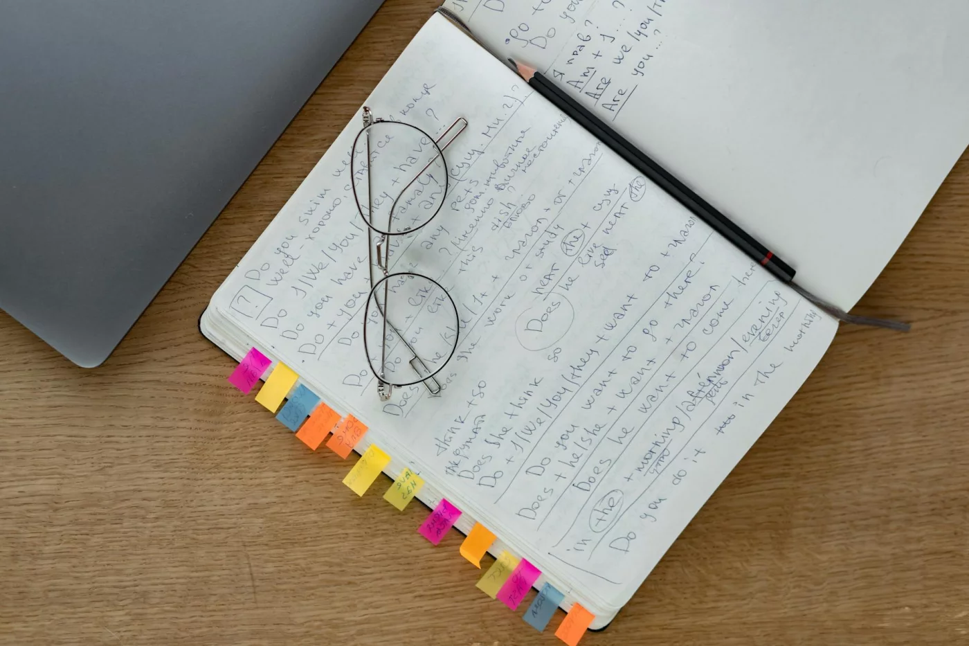 Notebook with handwritten notes, glasses, and pencil showing how to turn lecture notes into study guide