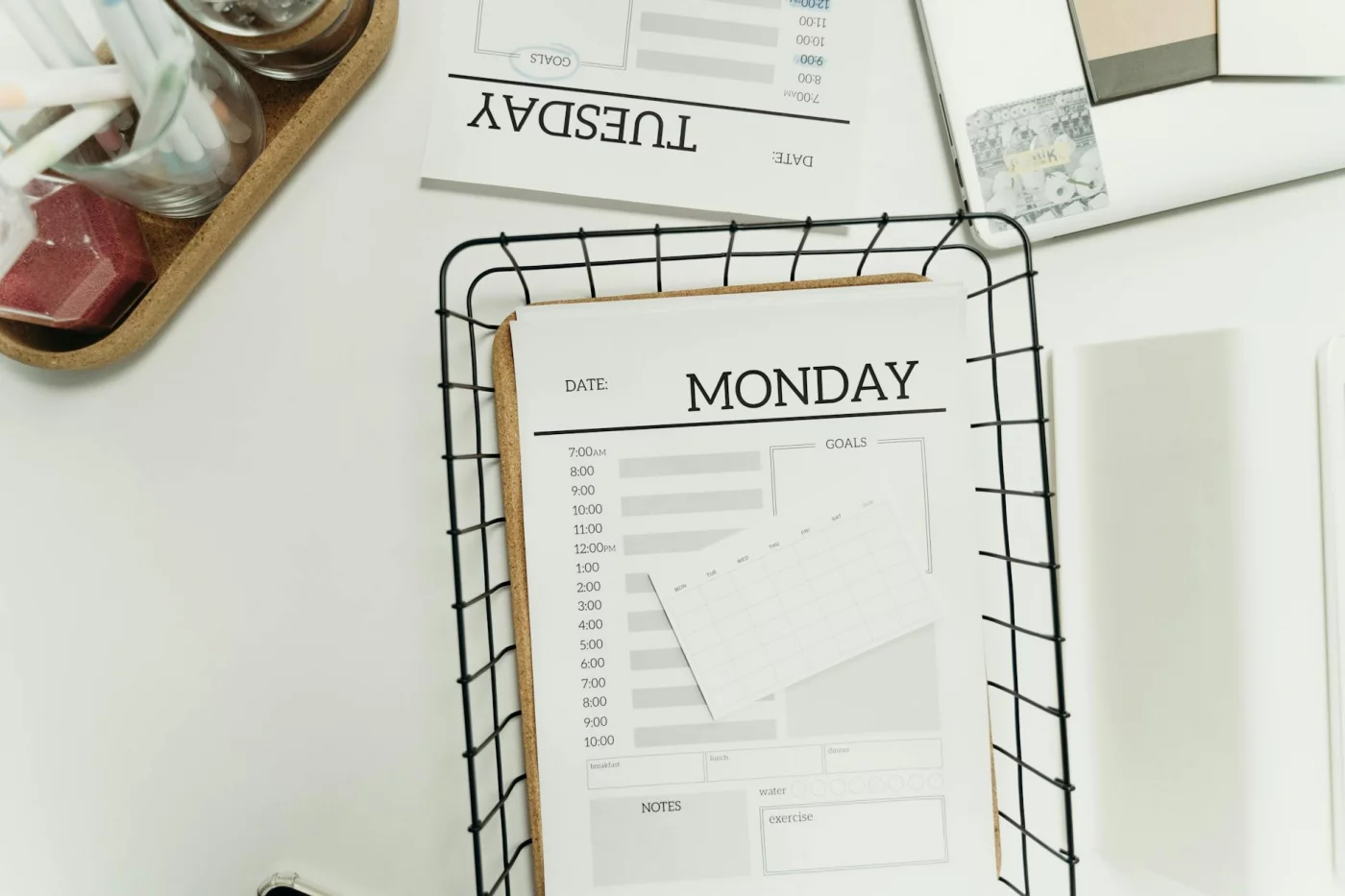 Minimalist undated weekly planner template with Monday and Tuesday pages, shown from above for FAQ section