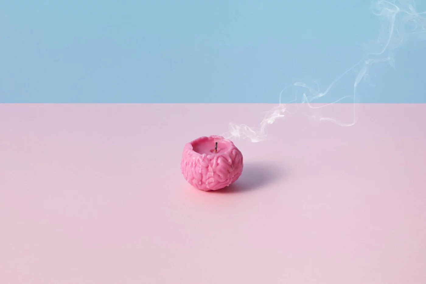 Memory Changes in Your 40s and 50s: What’s Normal vs Worrying Pink brain-shaped candle with smoke on pastel background illustrating what causes memory loss and forgetfulness