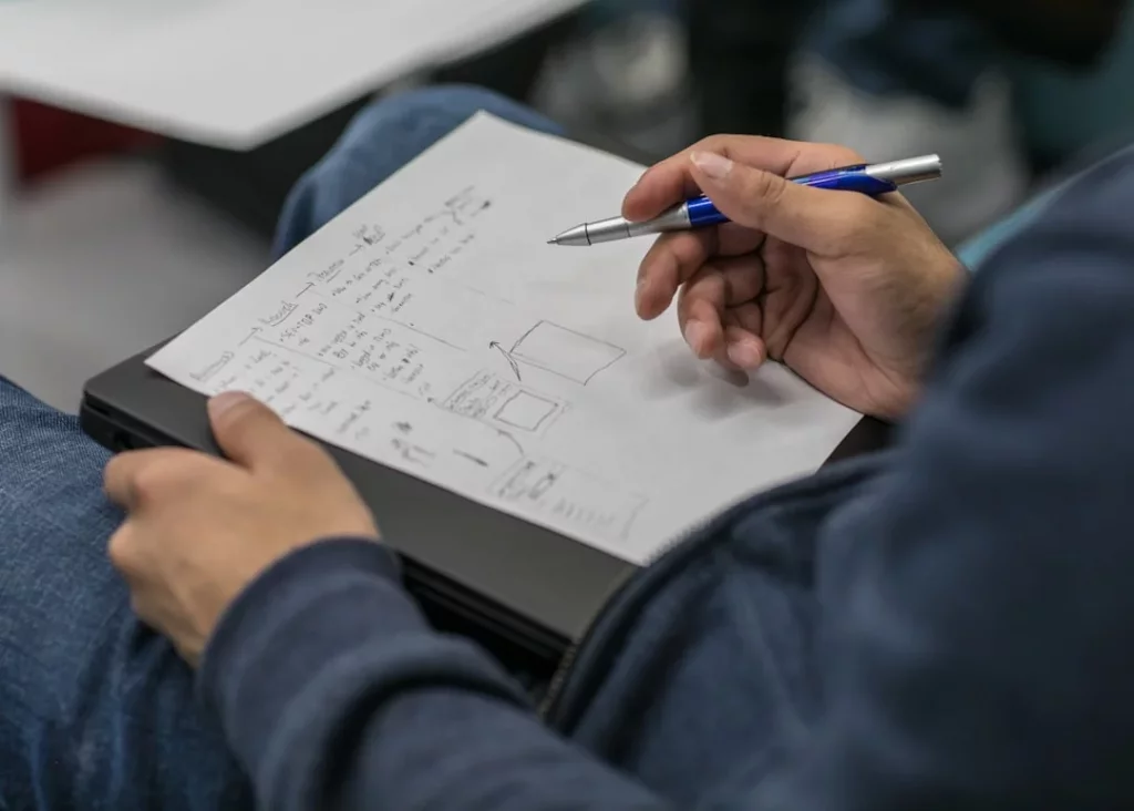 Student writing notes while studying what is the Atkinson Shiffrin model of memory for a psychology lesson