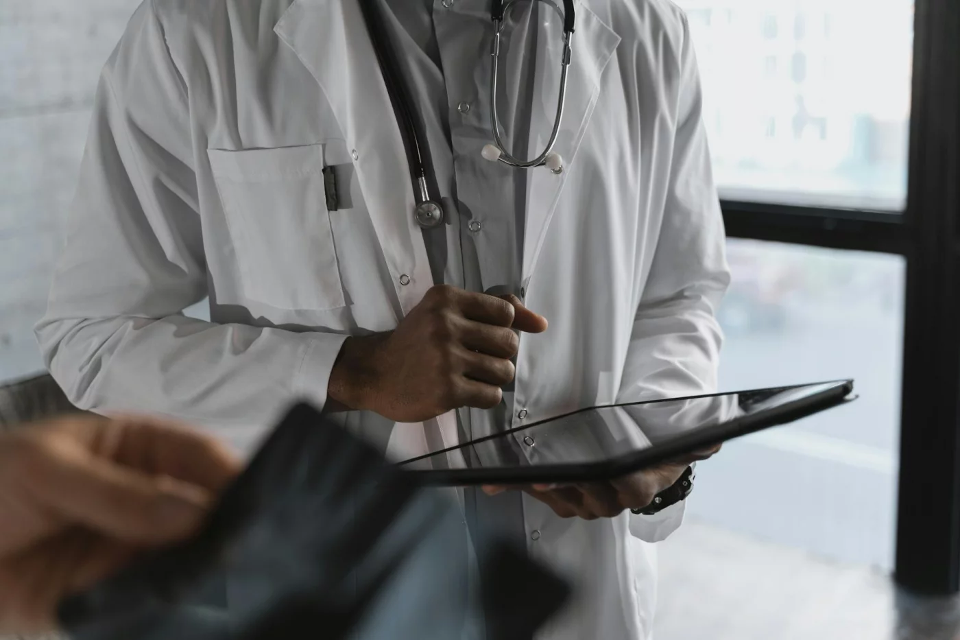 What Part of the Brain Is Responsible for Memory, Stress, Speech, and More? Medical practitioner reviewing FAQs on a tablet about what part of the brain is responsible for stress