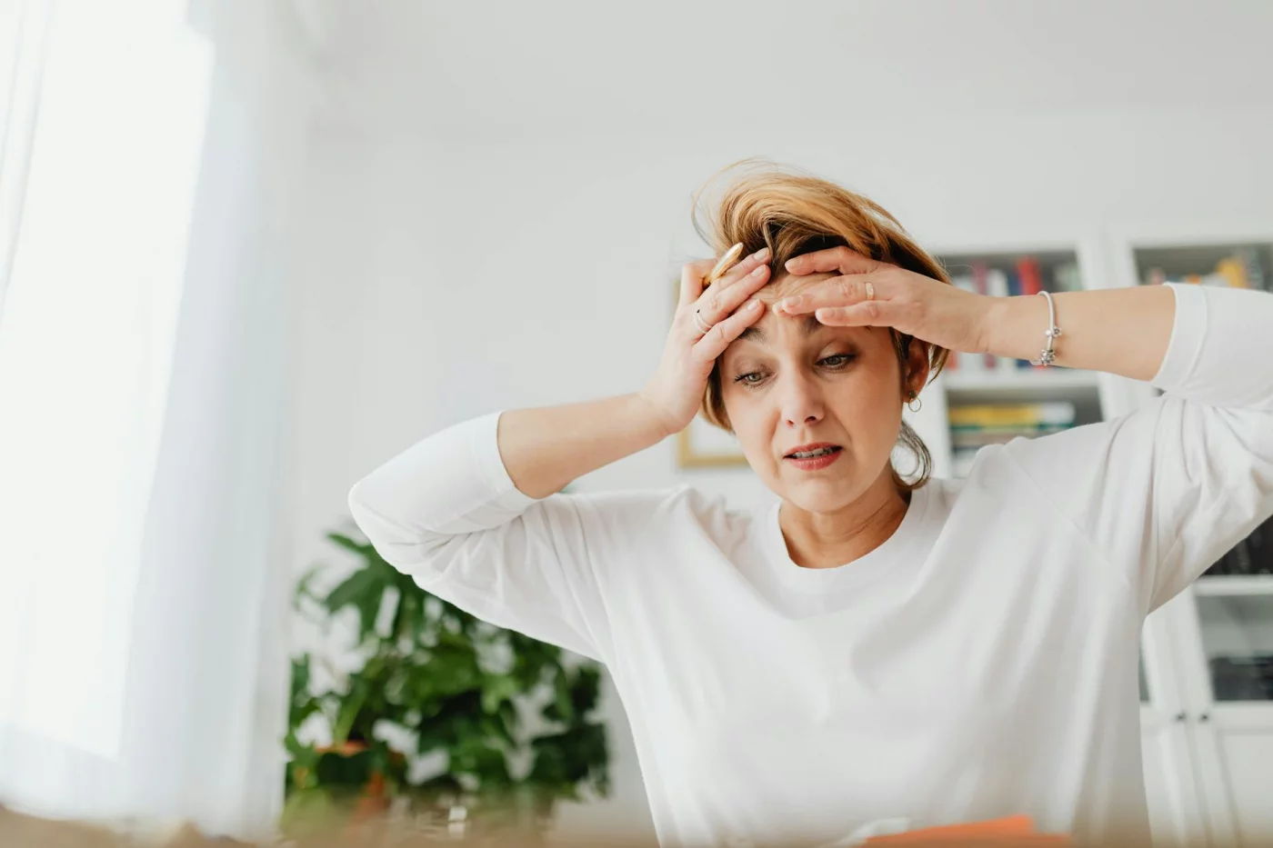 Why Do I Feel More Forgetful Lately? 6 Evidence-Based Reasons Worried woman holding her forehead while wondering why am i so forgetful lately and what to do next