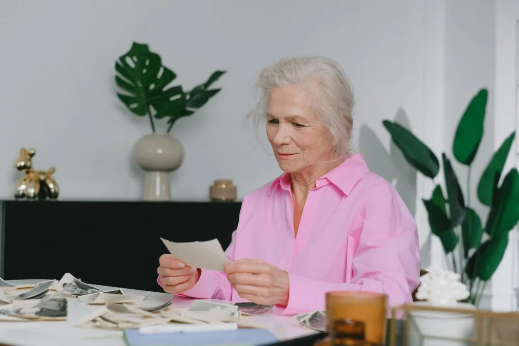 Why Emotional Events Feel So Unforgettable Elderly woman reflecting on old photos, showing why do we remember emotional events better over time